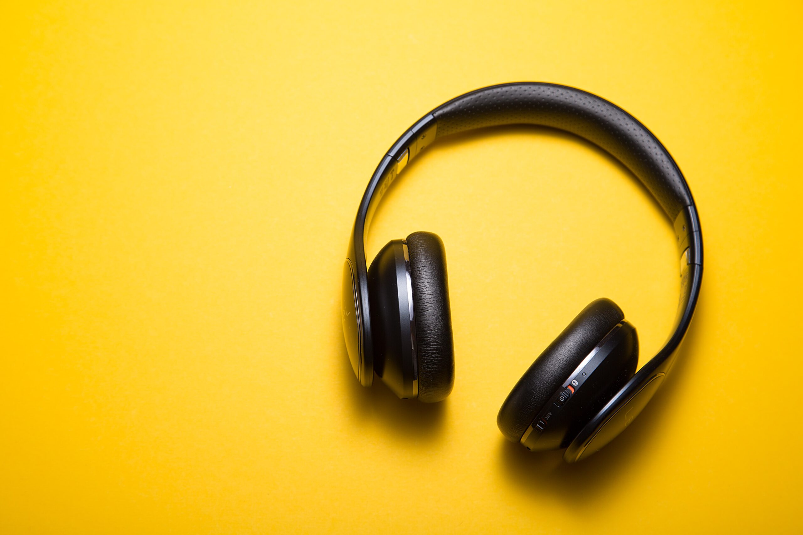 Mobile device with headphones wrapped around it, playing a podcast.