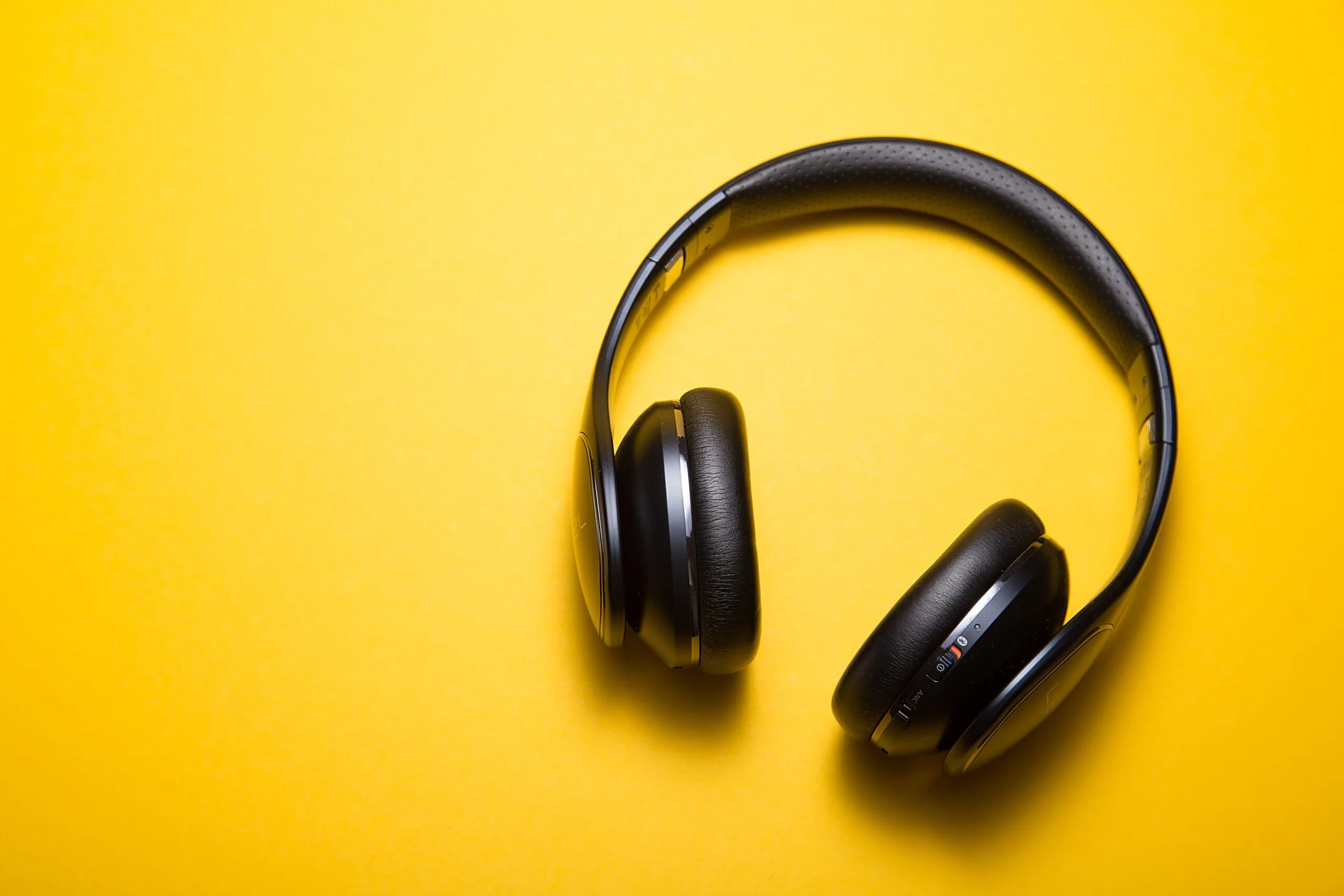 black headphones against a yellow background